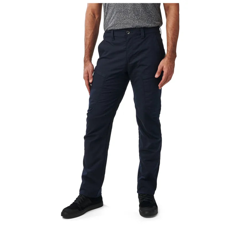 A person standing wearing dark navy tactical pants with multiple pockets and a comfort waistband.